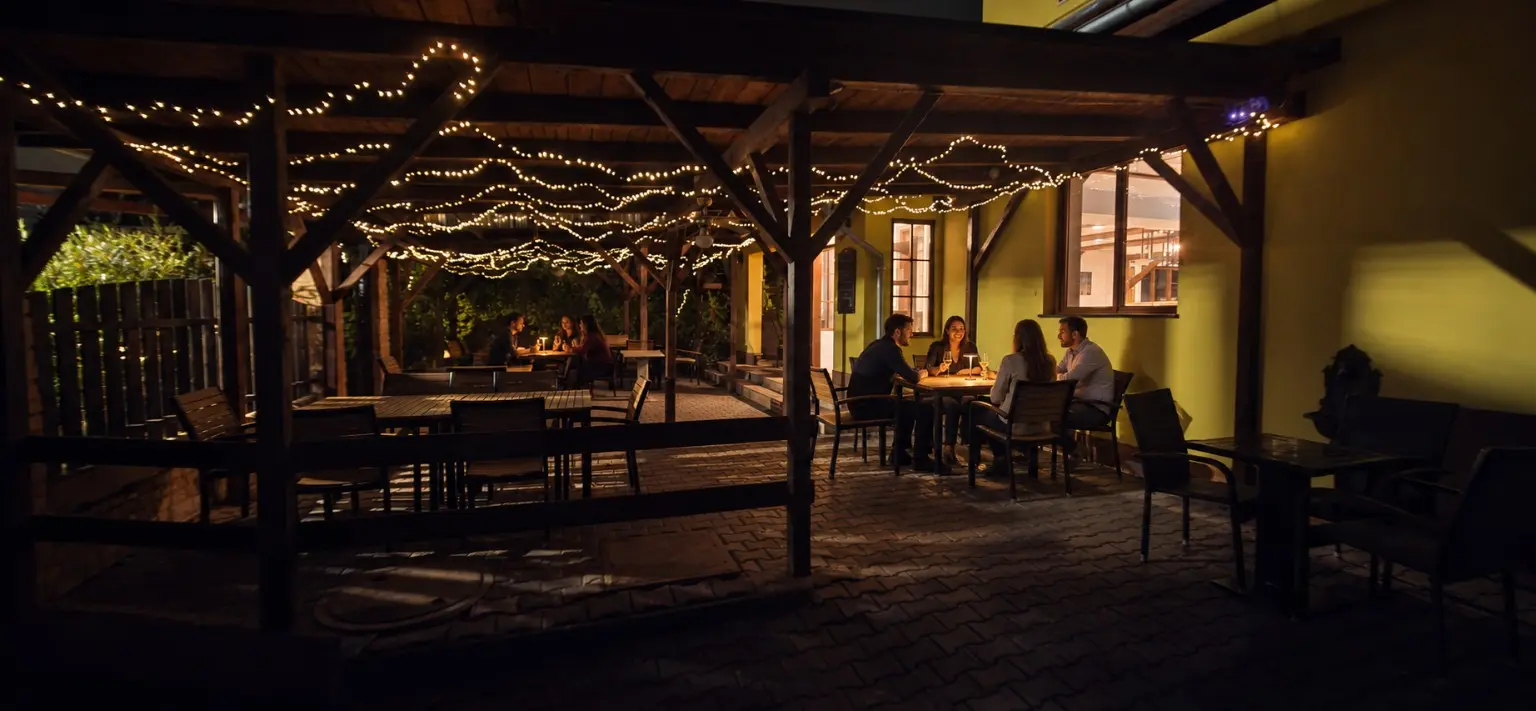 Večerní zahrádka restaurace Pod Hruškou se světýlky a lampičkami na stolech